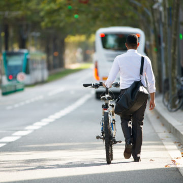 Businessman Walking with Bike in Street After Work BICICLETAS, TRANSPORTE Y DEPORTE DE MODA EN LA ERA DEL CORONAVIRUS